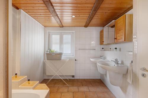 un bagno bianco con due lavandini e una finestra di M B Homes Schlatt Fewo 1 a Hechingen