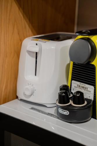 a white toaster sitting on top of a shelf at 1BR Mamsha Nest with balcony by BlueCloud Holidays in Sharjah Intl