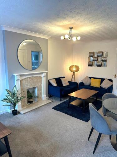 a living room with a blue couch and a fireplace at Central Chester Apartment, 2 beds, 3 guests in Chester