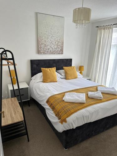 a bedroom with a large bed with yellow pillows at Central Chester Apartment, 2 beds, 3 guests in Chester
