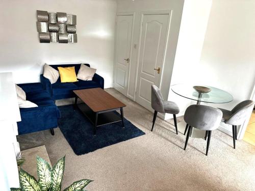 a living room with a blue couch and a table at Central Chester Apartment, 2 beds, 3 guests in Chester