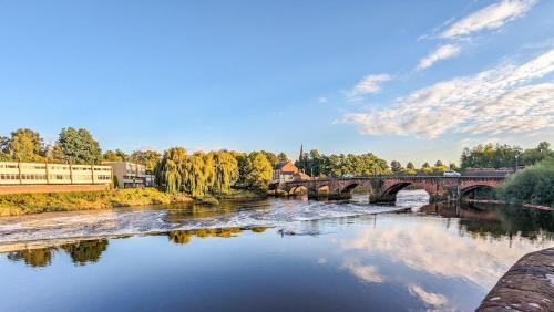 a bridge over a river with trees and buildings at Central Chester Apartment, 2 beds, 3 guests in Chester