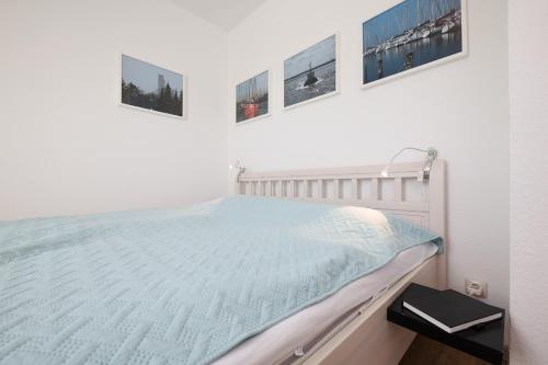 a bed in a room with three pictures on the wall at Yorikke in Laboe