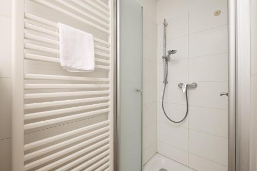 a white bathroom with a shower and a toilet at Yorikke in Laboe