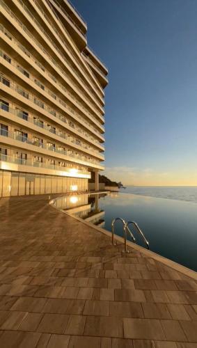 a large building next to a body of water at Sea View Dream Apartment in BambooBeach Tsikhisdziri in Tsikhisdziri