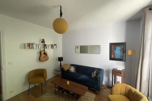 - un salon avec un canapé bleu et une guitare dans l'établissement Beautiful T2 - near Montmartre, à Paris