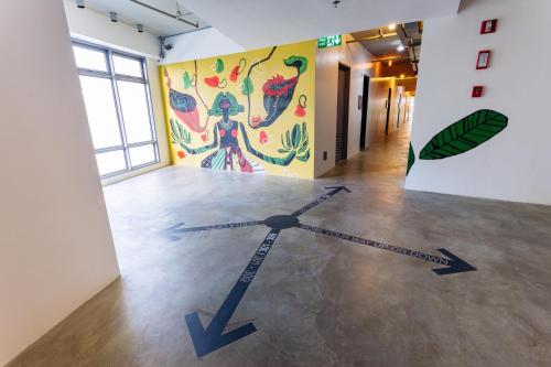 a clock on the floor in a room with a mural at Canvas Boutique Hotel in Puerto Princesa City