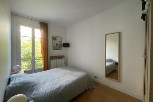 une chambre avec un grand lit et un miroir dans l'établissement Beautiful T2 - near Montmartre, à Paris