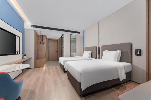 a hotel room with two beds and a flat screen tv at Holiday Inn Express Kunming Economic Dev Zone by IHG in Kunming