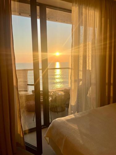 a bedroom with a bed and a view of the ocean at Sea View Dream Apartment in BambooBeach Tsikhisdziri in Tsikhisdziri