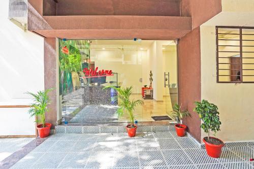 a lobby with a pool and plants in pots at Super Hotel O Sunshine Villa in Nagpur