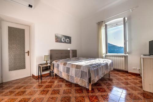 une chambre avec un lit et une grande fenêtre dans l'établissement Appartamento La Strilizia, à Camogli
