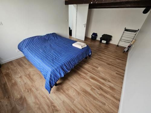 - une chambre avec un lit bleu et du parquet dans l'établissement Accueillant T2 avec terrasse privée, à La Rochelle