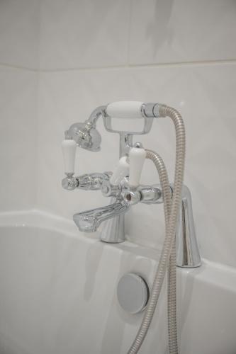 a bathroom sink with a faucet and a shower at Stirling Townhouse Apartment Btm in Stirling