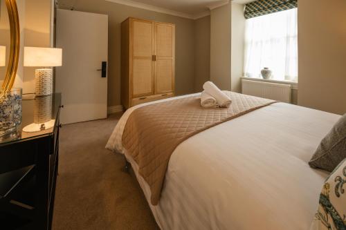 a bedroom with a bed with a towel on it at Stirling Townhouse Apartment Btm in Stirling