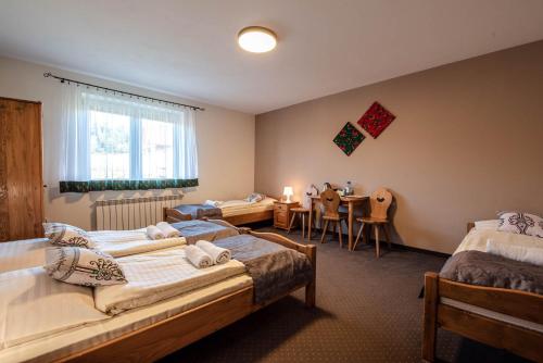 a bedroom with two beds and a dining room with a table at Willa Karolina in Czorsztyn