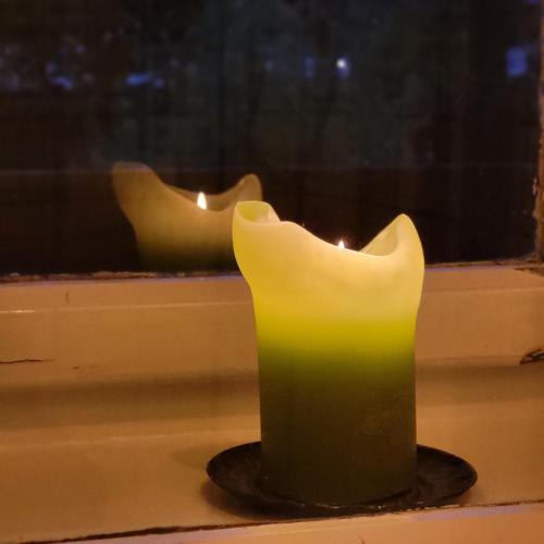 a yellow candle sitting on a window sill at Sachserhof Ferienwohnungen in Sachsenburg in Sachsenburg