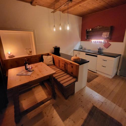 a living room with a table and a kitchen at Sachserhof Ferienwohnungen in Sachsenburg in Sachsenburg