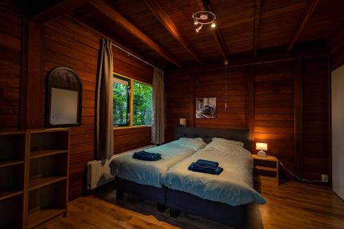 Un dormitorio con una cama en una habitación con paredes de madera. en Vacation Home North Limburg, en Blitterswijck