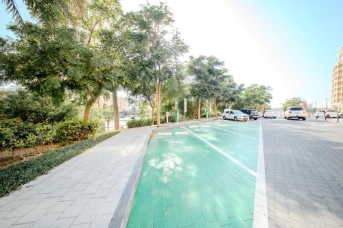 an empty street with green paint on the road at 1Bedroom & Living room Apartment - The Sahara Suite in Sharjah Intl