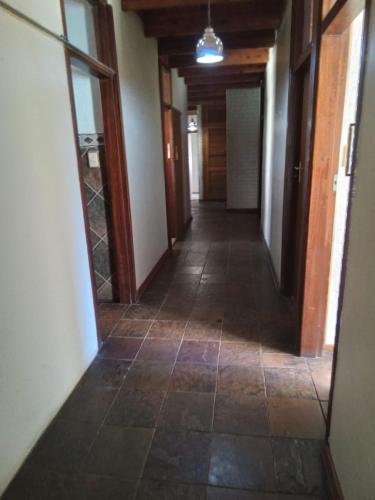 an empty hallway with a tile floor and a mirror at Vryburg Good Time Yafe Guest House in Vosburg
