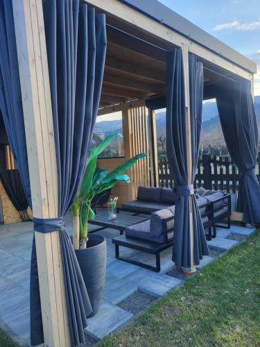 un patio con tende blu e mobili su un tetto di Sielska Ostoja a Brenna