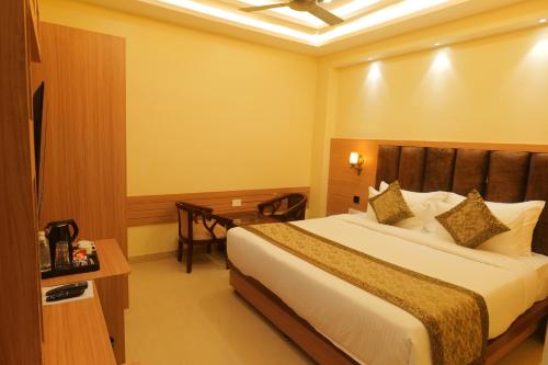 a hotel room with a bed and a desk at Hotel Mantavya in Kakarmatha