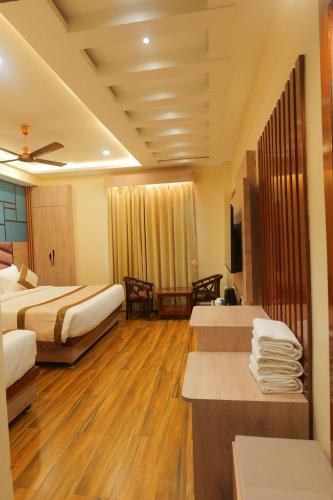 a hotel room with two beds and wooden floors at Hotel Mantavya in Kakarmatha