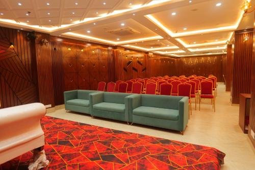 a conference room with red chairs and a green seat at Hotel Mantavya in Kakarmatha