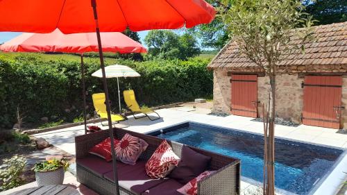 une terrasse avec un canapé, un parasol et une piscine dans l'établissement La Popinette Chambre d'hôte, à Saint-Bonnet-de-Joux