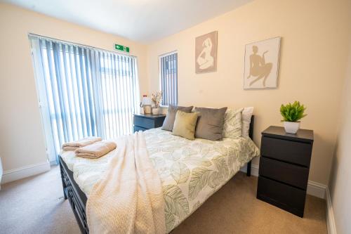 a bedroom with a bed and a large window at Family,Cosy 2 Bedroom Apartment with Garden Close to Town, Seafront, Hospital, Free Parking in Eastbourne