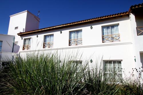 a white building with windows on the side of it at La Campiña Club Hotel & Spa in Santa Rosa