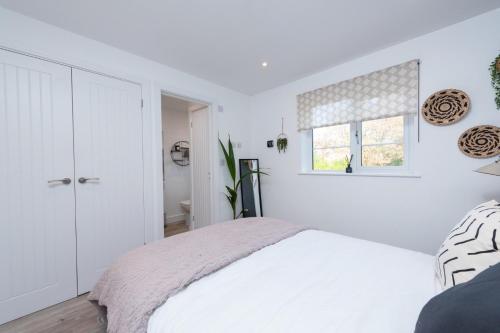 a white bedroom with a bed and a window at Bridge House - 1-Bed with Sofabed in Stratford-upon-Avon