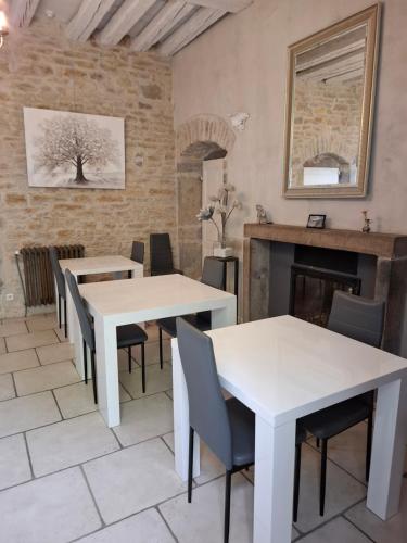 une chambre avec des tables, des chaises et une cheminée dans l'établissement Maison d'Eusébia, à Château-Chalon