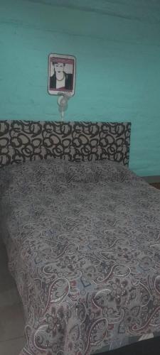 a bed in a bedroom with a picture on the wall at la flor del lugar in Potrerillos