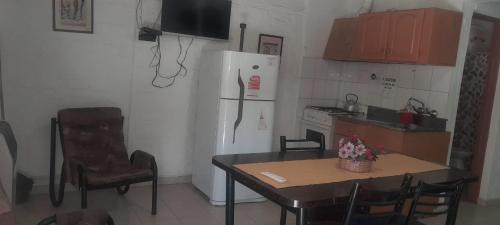 a kitchen with a table and a white refrigerator at la flor del lugar in Potrerillos