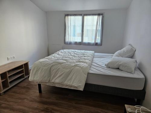 une chambre blanche avec un lit avec une fenêtre dans l'établissement peaceful new home T2, à La Rochelle