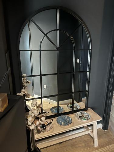 un miroir sur une table avec des assiettes dessus dans l'établissement Spacious flat with terrasse and parking near metro, à Bagnolet
