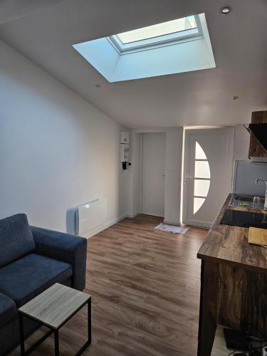 - un salon avec un canapé bleu et une lucarne dans l'établissement peaceful new home T2, à La Rochelle