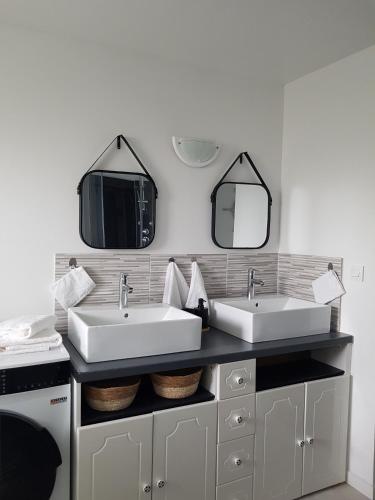 a bathroom with two sinks and two mirrors at Odyssée-Le Nautile in Béthisy-Saint-Pierre
