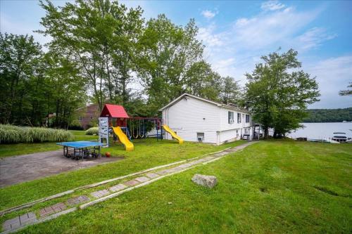 a backyard with a playground with a house at Catskills Lakefront with Hot Tub, Sauna and Theater in Monticello