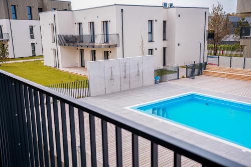 a balcony with a swimming pool in front of a building at Takas į Jūrą Resort in Palanga