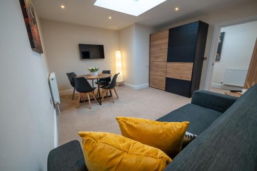 a living room with a blue couch and a table at Family,Cosy 2 Bedroom Apartment with Garden Close to Town, Seafront, Hospital, Free Parking in Eastbourne