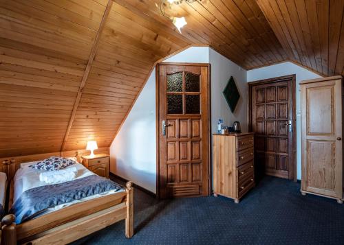 a bedroom with a bed and a wooden ceiling at Willa Karolina in Czorsztyn