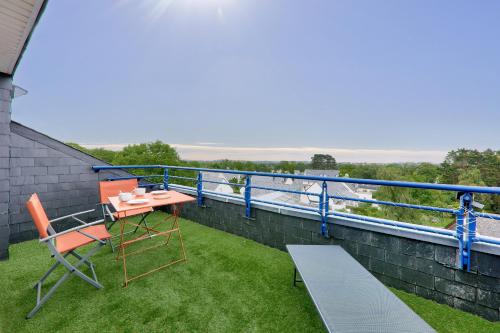 a balcony with a table and chairs on the grass at Appartement pour 4 avec grand balcon in Sarzeau