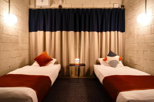 two beds sitting next to each other in a room at Spice Motel Okinawa in Kitanakagusuku