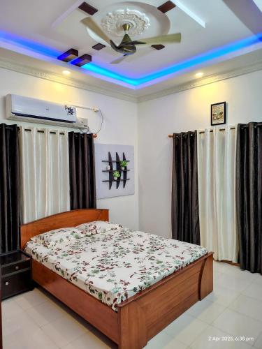 a bedroom with a bed and a ceiling fan at Kinaara Homestay Thottam Malpe Beach Udupi in Malpe