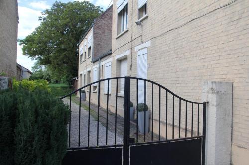 une porte en métal noir devant un bâtiment dans l'établissement Studio au village à Mastaing, à Mastaing