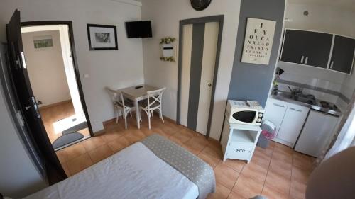 Cette petite chambre comprend un lit et une petite cuisine. dans l'établissement Studio au village à Mastaing, à Mastaing