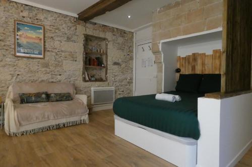 une chambre avec un lit et un canapé dans l'établissement petit chateau rouge - Hypercentre - rénové, à Nantes